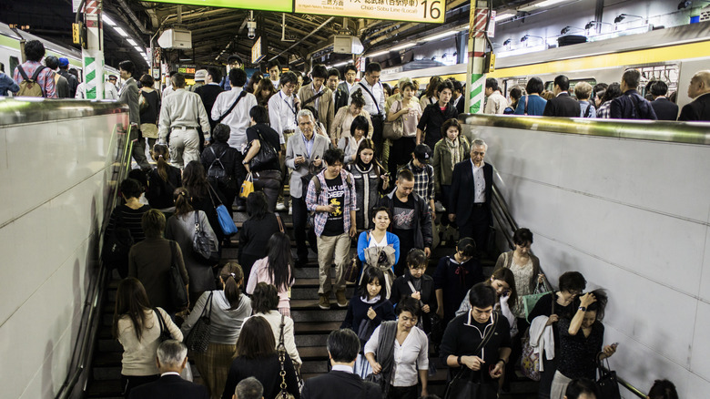 People moving through the stairwell of a crowded Tokyo train station