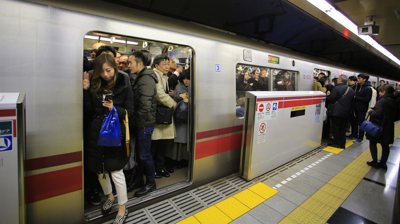 Woman exiting a crowded subway train in Japan
