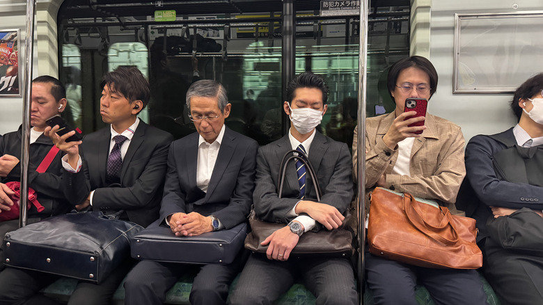 People on the train in Japan reading and sleeping