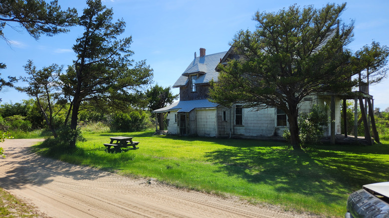Life-Saving Station at Cape Lookout Village on a green lawn with a picnic table out front