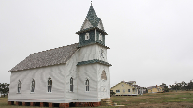 A white church and homes in the backdrop in Portsmouth Village, North Carolina
