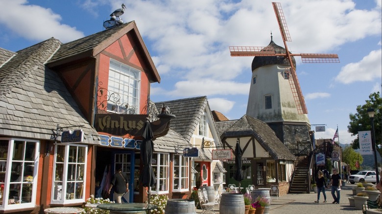 Two people walking under a windmill in Solvang, California