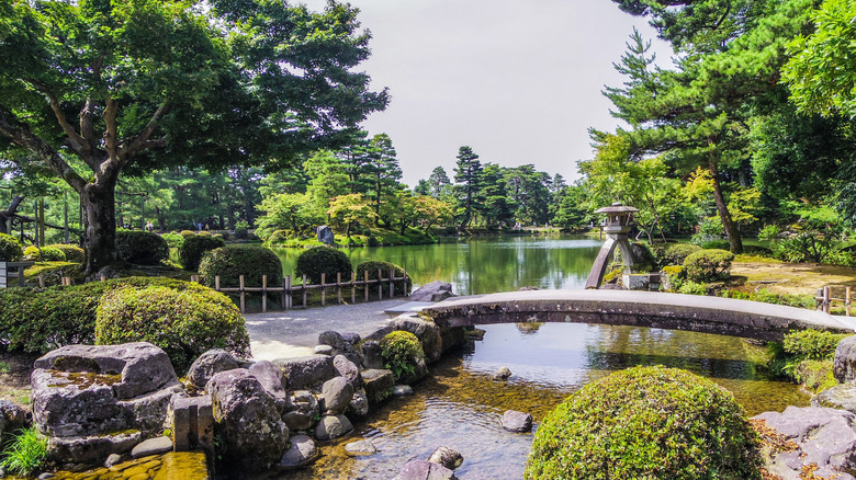 a japanese garden with pond and stone bridge