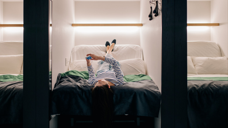 woman laying in capsule hotel bed