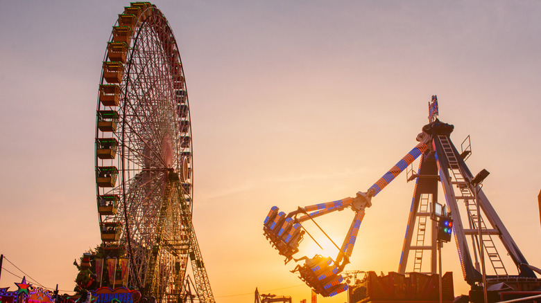 Amusement park attractions such as a ferris wheel at sunset