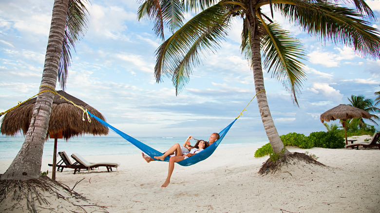 Vacationers relaxing on a hammock 