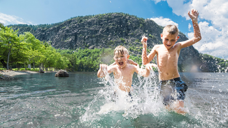 two boys splashing in the waters of Mooshead Lake in Maine
