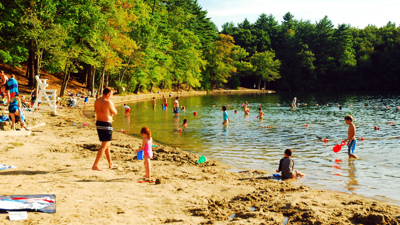 Families swimming on a sandy beach with a lifeguard station at Walden Pond in Concord, Massachussets in New England