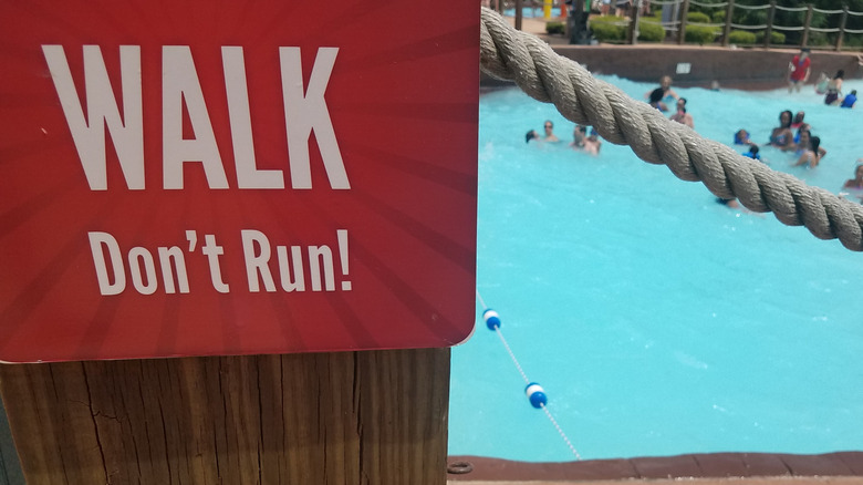 A safety sign near a pool in a water park