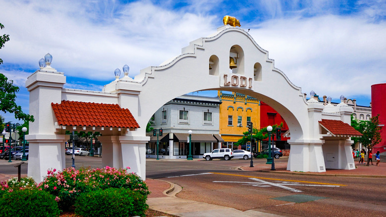 White arched entrance to Lodi, California, against a backdrop of colorful buildings
