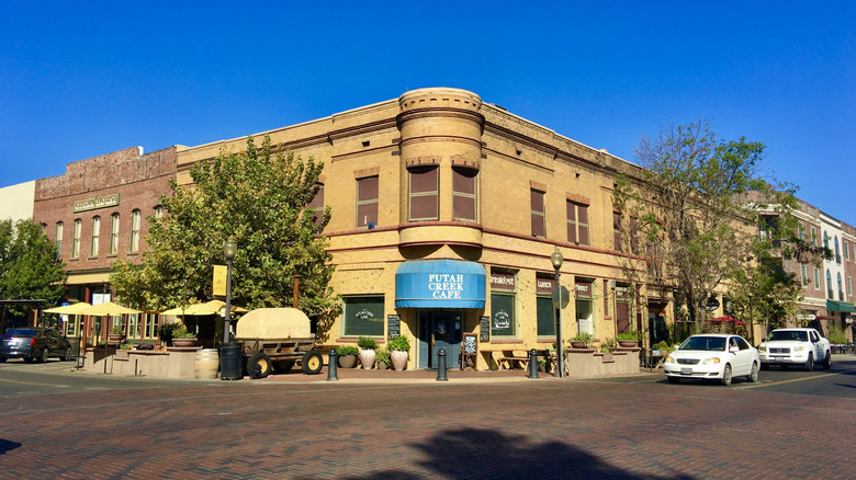Putah Creek Cafe with blue awning on a street corner next to a historic brick building in Winters, California