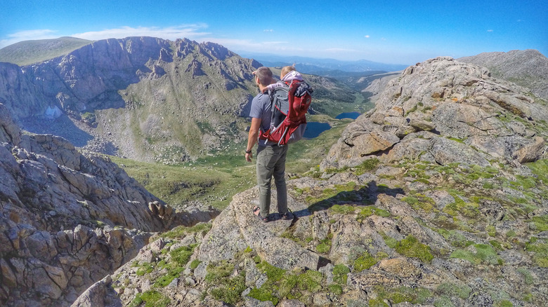 A hiker at the top of a fourteener, Mt. Evans