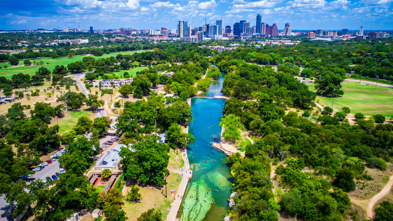 Aerial view of Barton Springs Pool with Austin skyline in the background