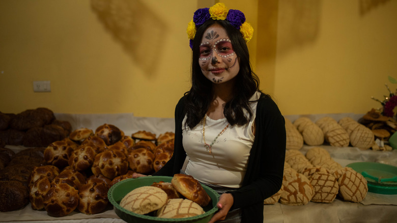 A woman carrying Pan de Muertos during the popular Dia de Los Muertos festival