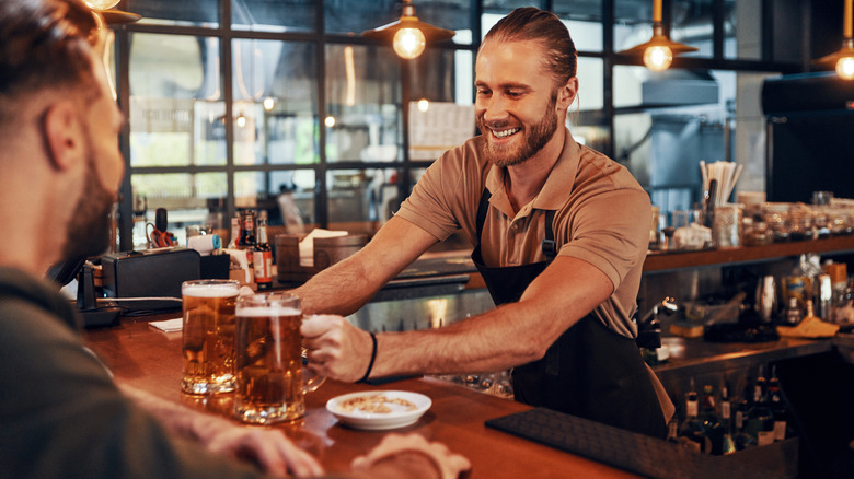 A bartender having a conversation with a patron of his bar