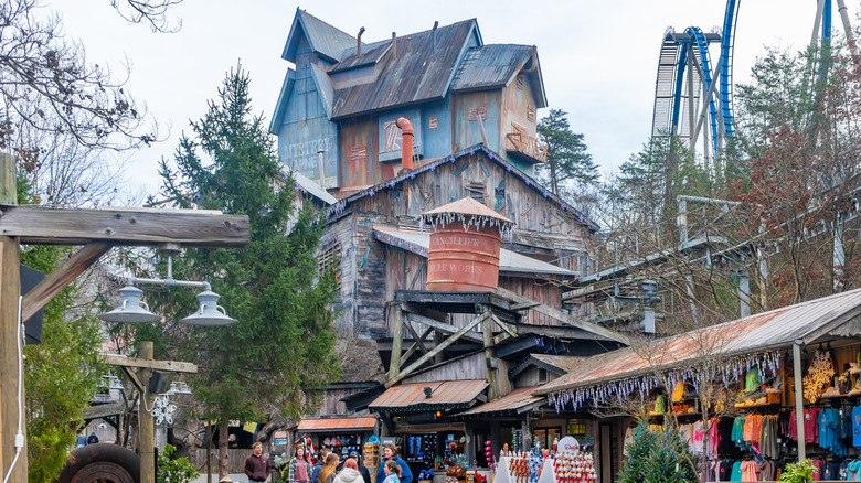 Tourists walk through the Dollywood theme park with the Mystery Mine in the background