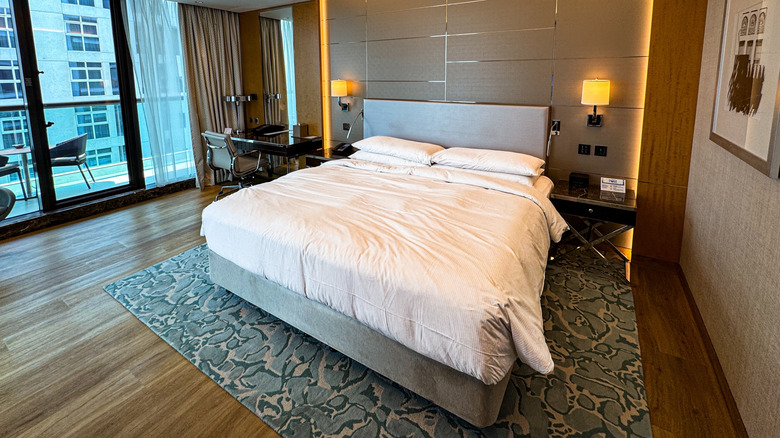 View of a hotel room with a balcony and modern furnishings inside Hilton Palm Jumeriah Dubai