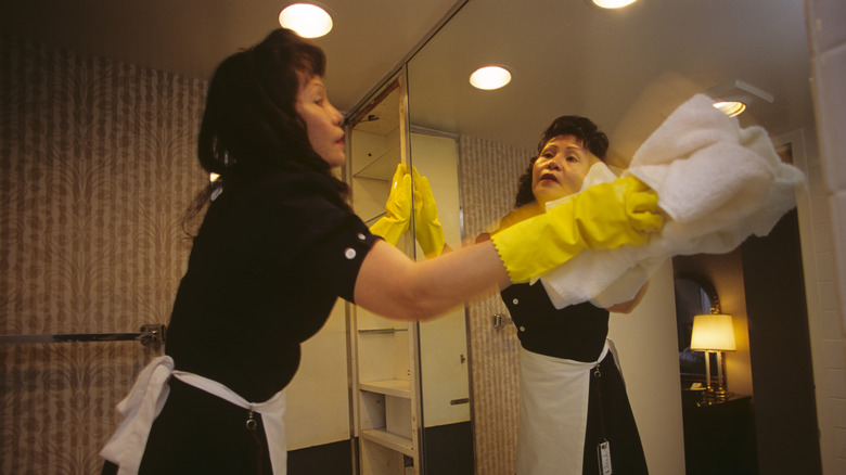 Uniformed maid cleans a mirror at the Hilton Washington Hotel