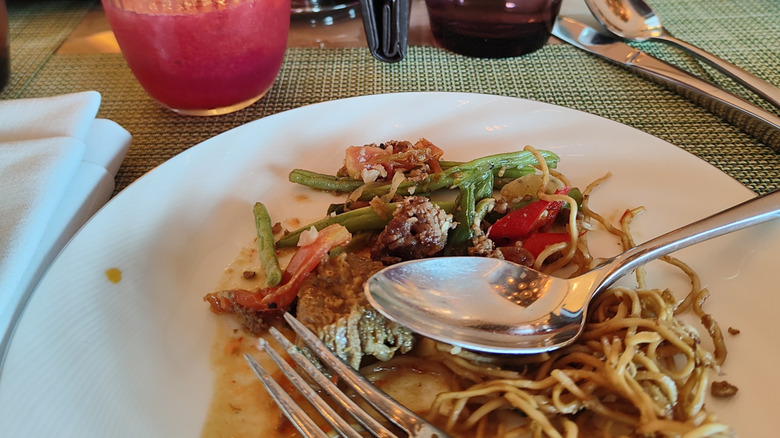 Plate with noodles, salad, and colorful drinks on a restaurant table at Park Hyatt Jakarta