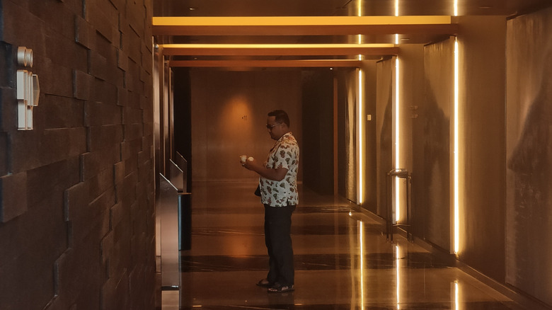 Warm-colored hallway and elevator area with wood-paneled hotel interior at Park Hyatt Jakarta