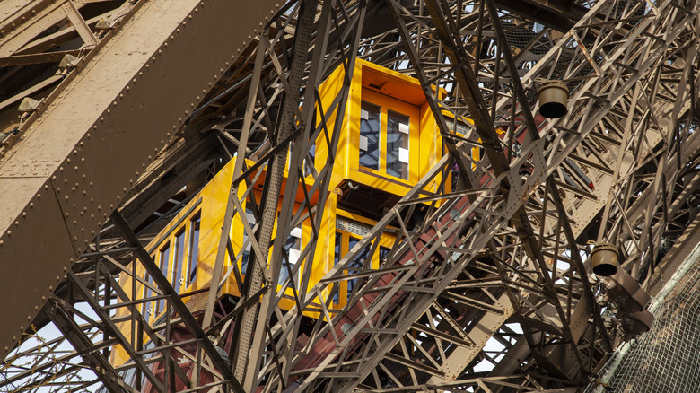 Close-up view of yellow elevator inside the Eiffel Tower structure