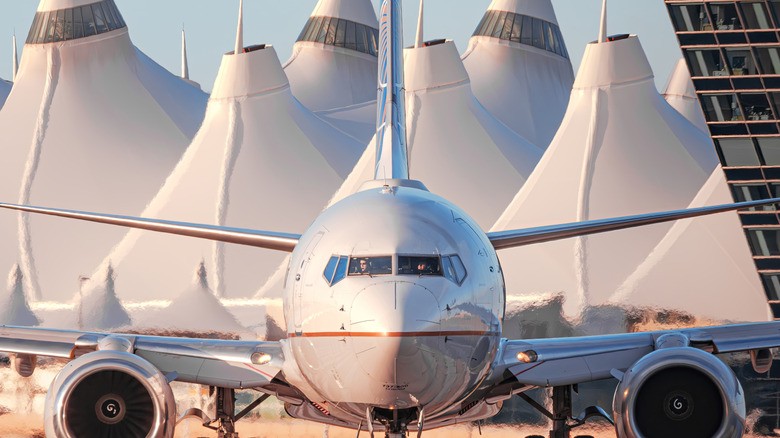 Passenger jet getting ready to takeoff from Denver International Airport with the airport's famous tented roof in the background