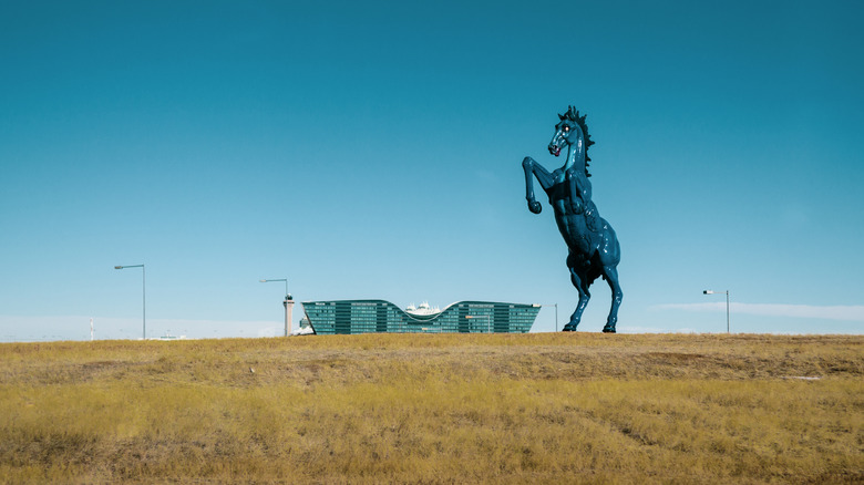 Daytime view of oversized blue mustang statue that welcomes people to Denver International Airport