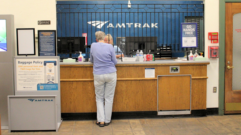 Customer service agent helping a customer at an Amtrak ticket counter
