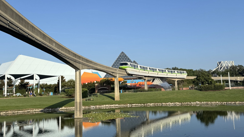 View of the Disney World Monorail passing in front of the Journey Into Imagination building at EPCOT with a clear blue sky