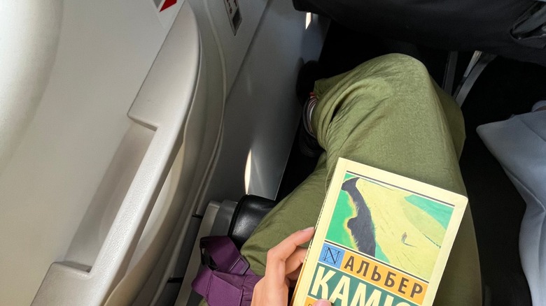 An airlines emergency exit seat pressing into a passenger's space