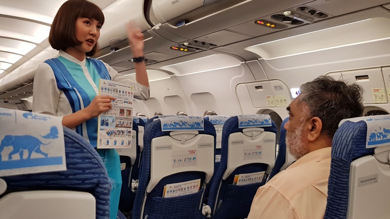 An airplane passenger learning his emergency row duties