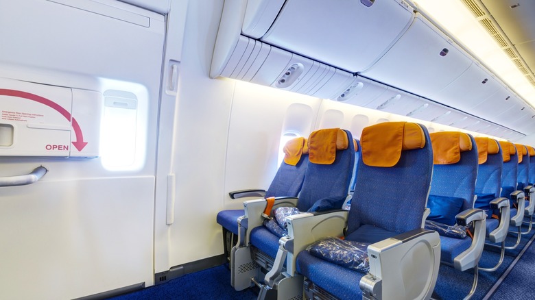 A row of airplane seats next to the emergency exit