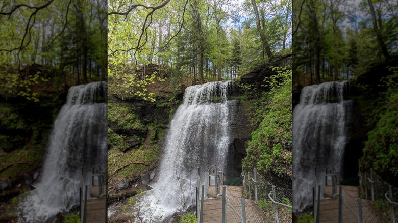 Buttermilk Falls, a large waterfall, with a wooden walkway with metal railings in the foreground, surrounded by moss-covered cliffs and trees