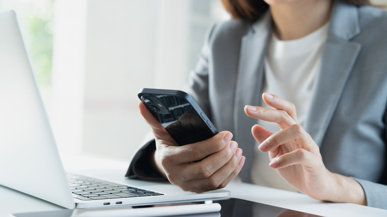 A happy businesswoman works on her smartphone