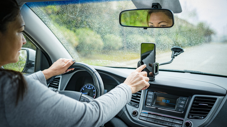 Woman checking maps in on her phone while driving