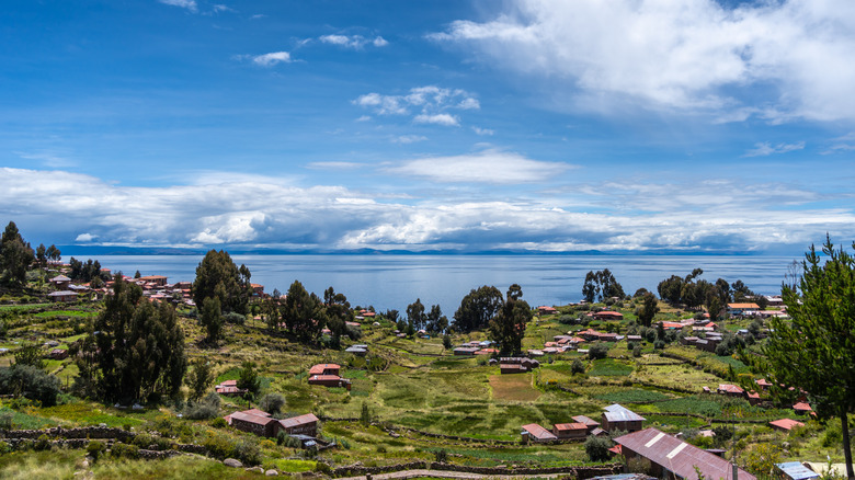 Traditional houses with red roofs and cultivated fields on Taquile Island, overlooking Lake Titicaca, Peru