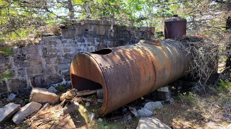 Crumbling wall and rusted tank from the ghost town of Perkins on Swan Island, Maine