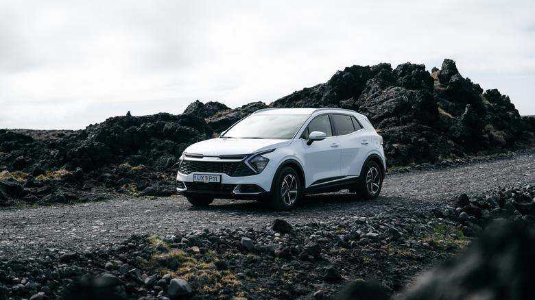 New Kia Sportage car on desert road near volcanoes in Iceland