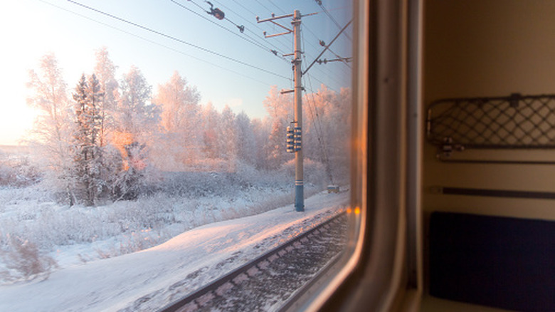 Pink sunrise outside of a train window.
