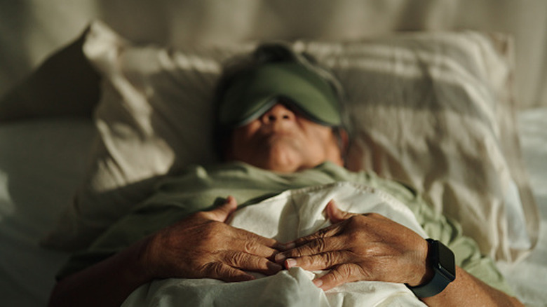 An elderly woman sleeping in a sleeping mask.