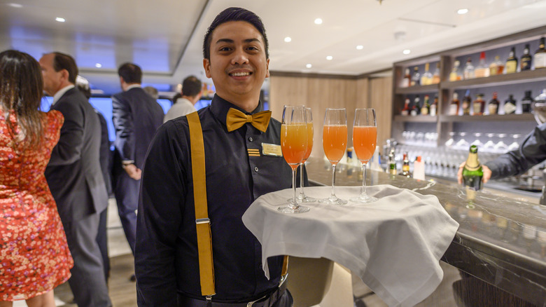 A waiter offers drinks to visitors in the lounge of MS World Explorer