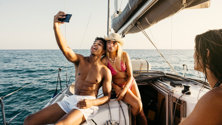 Young attractive couple taking selfies on a boat