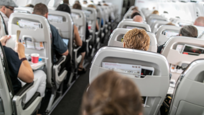 Interior of commercial airplane with passengers in their seats during flight