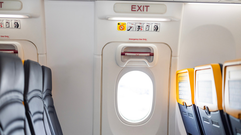 Emergency exit in the cabin of an airplane situated between two rows of seats