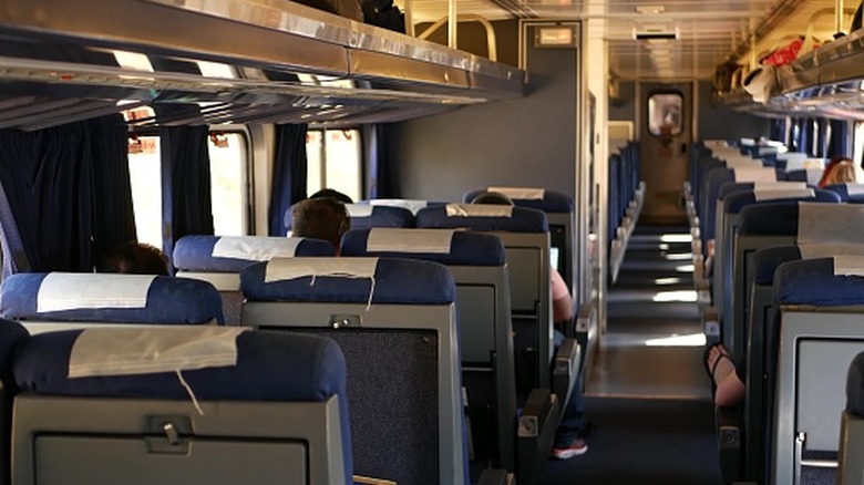 View of passengers riding in an Amtrak Pacific Surfliner commuter train car, listening to music and being quiet