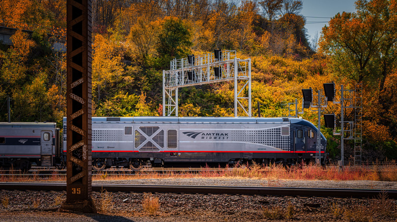 An Amtrak train driving against the scenic fall forest in Kansas City, US