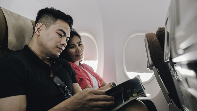 Man reading a magazine on airplane
