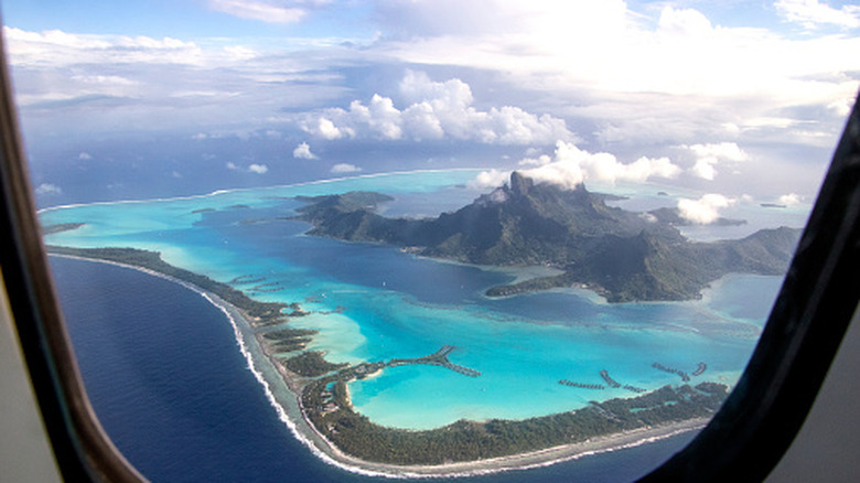 view from a window as an airplane comes in for a landing on beautiful Bora Bora. French Polynesia, South Pacific Ocean.