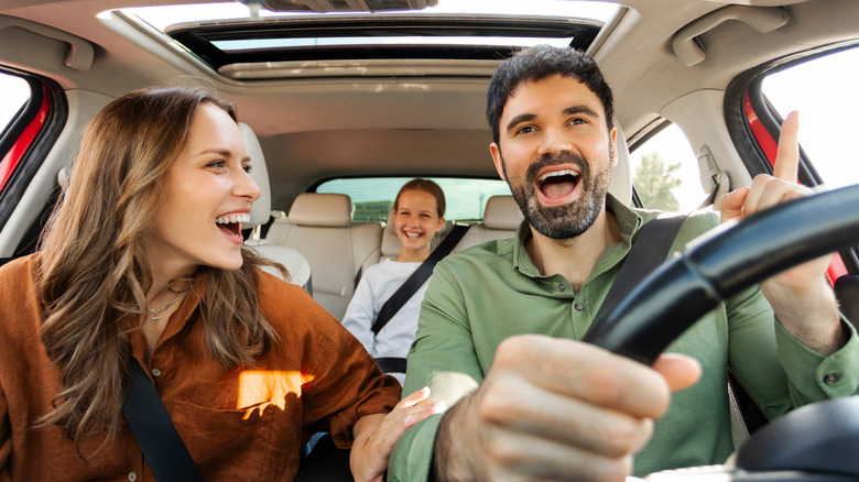 People singing in car on road trip