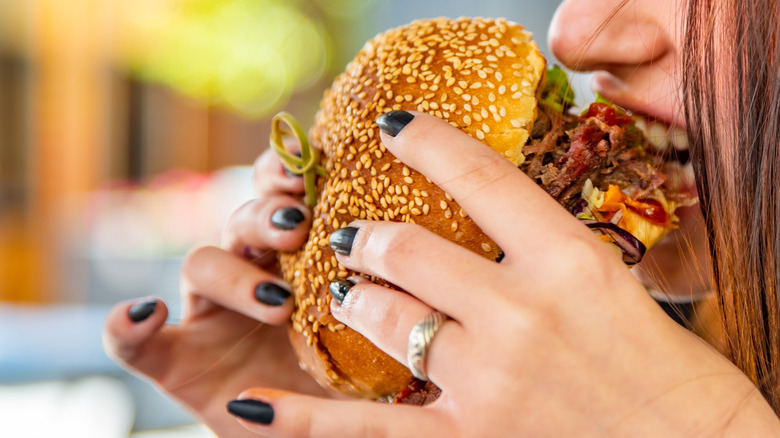 Woman eating bbq chicken sandwhich
